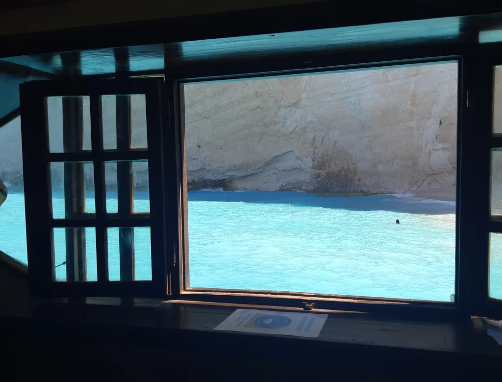 Fenêtre de bateau donnant sur la plage de Navagio sur l'ile de Zakynthos